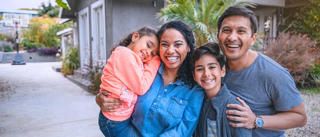 Happy family in front of their house