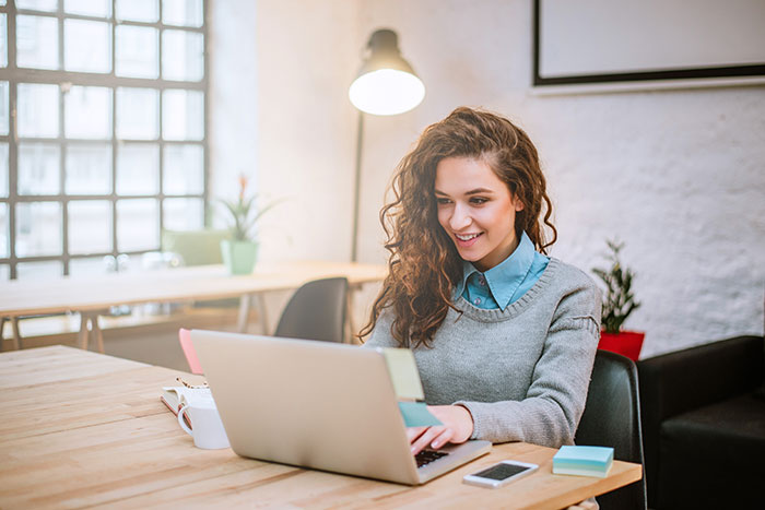 Smiling young female working on a laptop