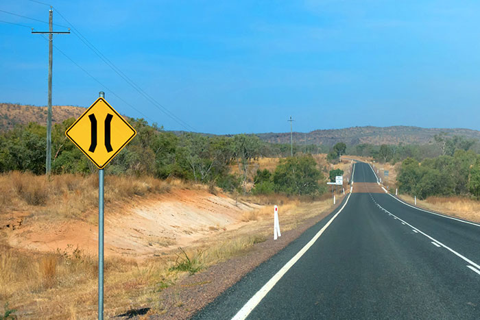 Road narrows sign near road in queensland