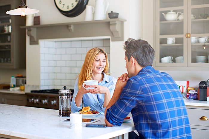 Happy young couple having breakfast at home 