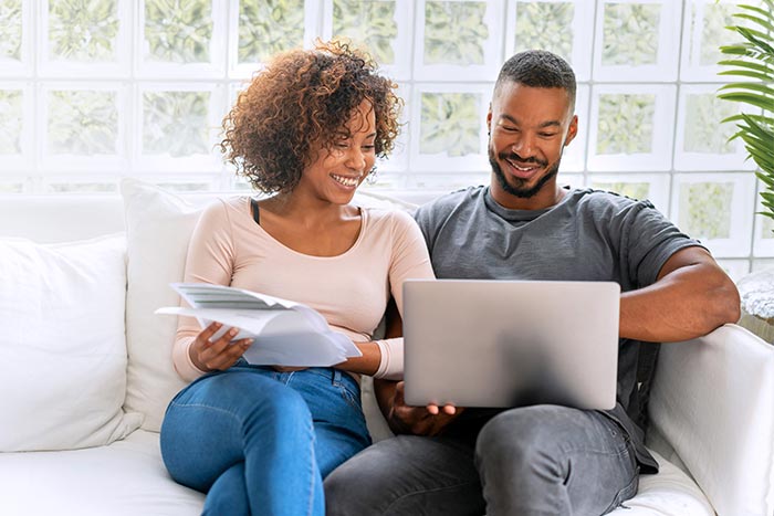 Loving couple paying bills online at home