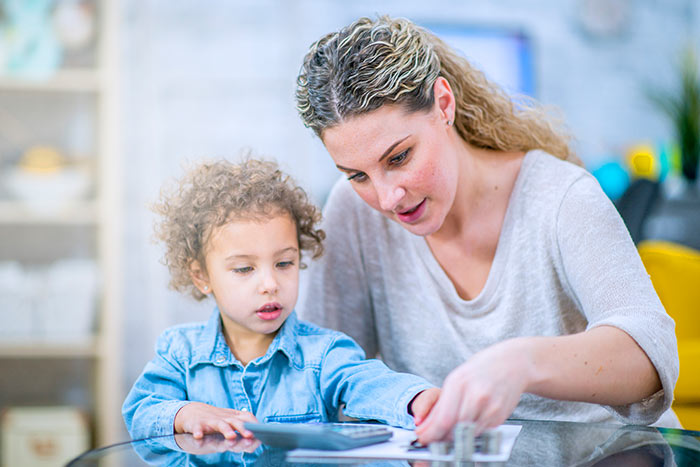 Mother teaching her daughter how to count money