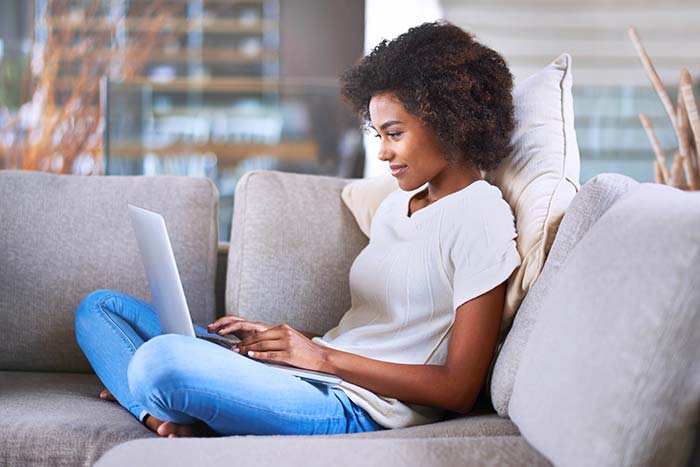 young woman using a laptop while relaxing at home