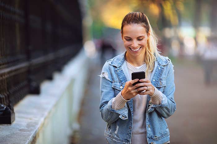 Smiling lady typing a text message