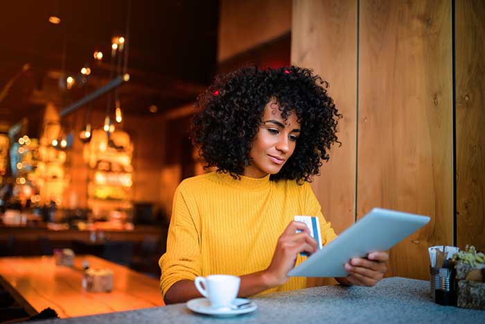 African american woman using digital tablet at the bar