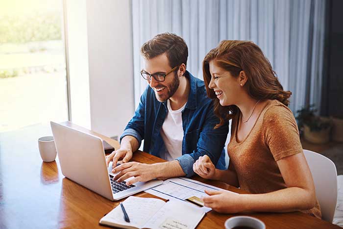 Young couple doing online shopping on a laptop together at home