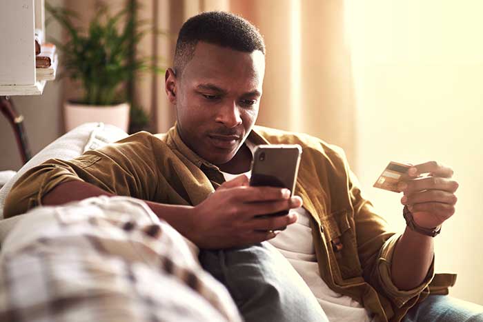 Young man using a smartphone and a credit card