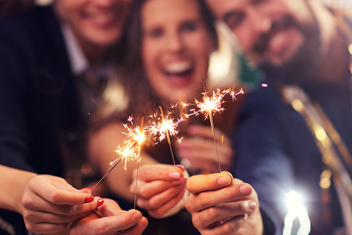 3 people holding sparkles