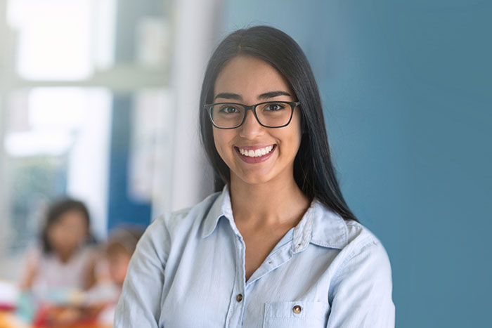 Teacher smiling wearing a black glasses.
