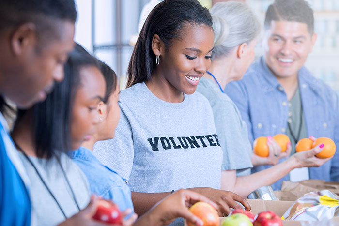 Cheerful family volunteering pack donated food