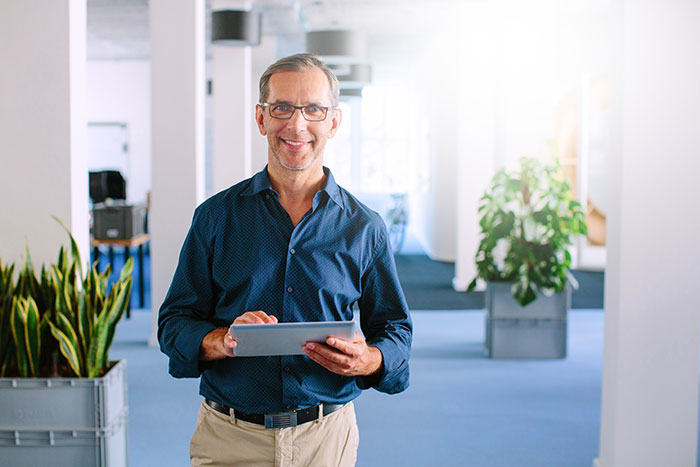 A guy wearing blue shirt wearing glasses.