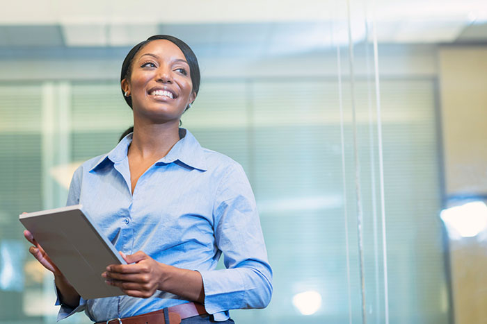 African american woman in office holding digital tablet
