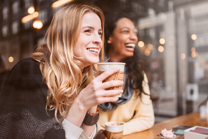 Girlfriends sharing a laugh in coffee shop