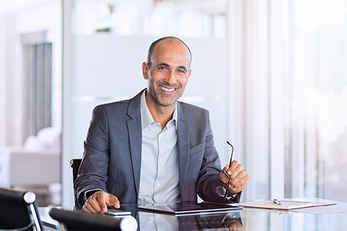 Mature business man smiling at his desk