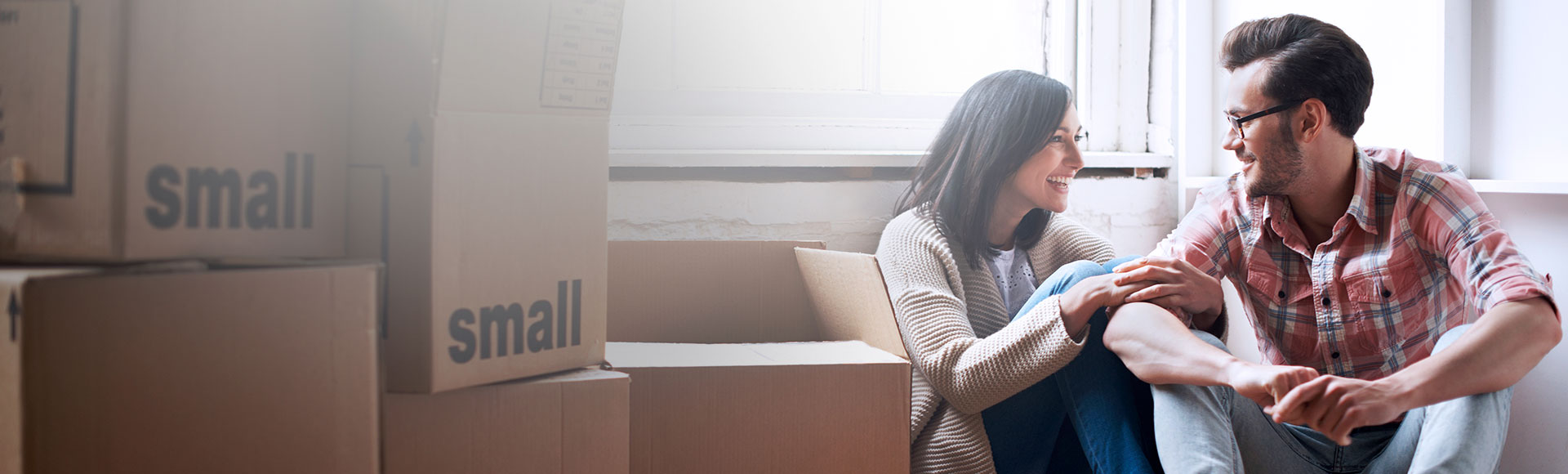 Couple sitting down and unpacking boxes