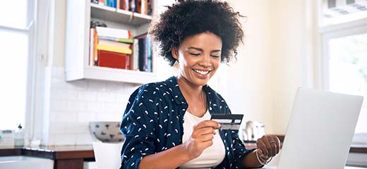Young woman using credit card to purchase online
