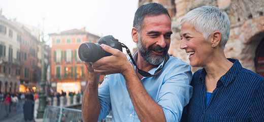 Mature couple taking photos as tourists in city verona