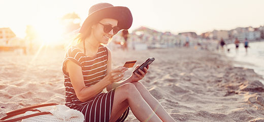 Woman using credit card at the beach