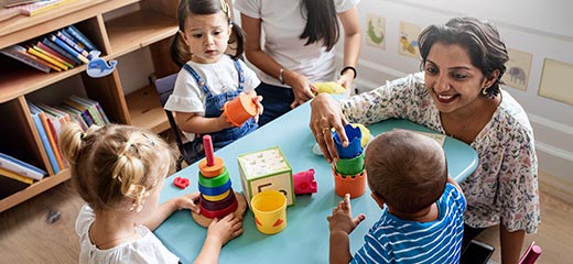 Preschool children playing with teacher in the classroom