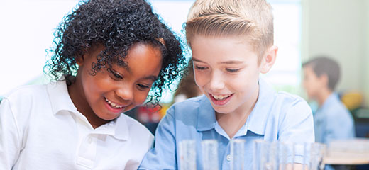 Cheerful STEM school students work on science experiment