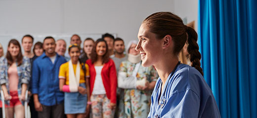 Nurse smiling and sitting at her desk in hospital